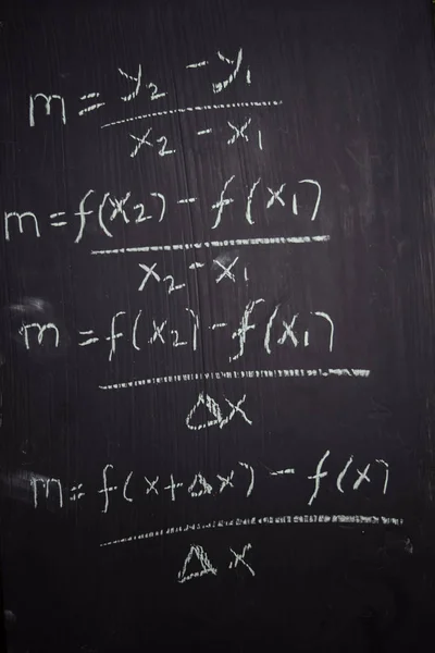 Feche as fórmulas matemáticas escritas em um quadro negro. Conceito de educação Fotografia De Stock