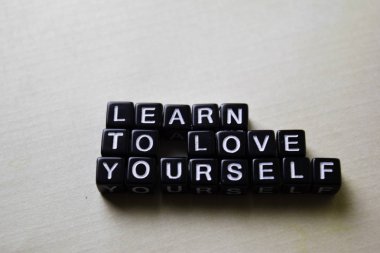 Ahşap bloklar üzerinde Kendinizi Sevmeyi öğrenin. İş ve ilham konsepti