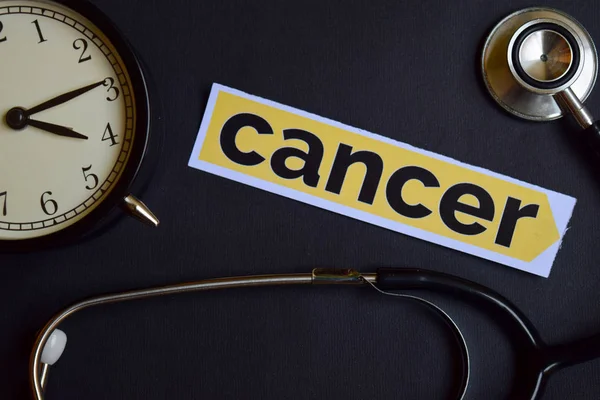 Cancer på skrivpapper med hälso-koncept inspiration. väckarklocka, svart stetoskop. — Stockfoto