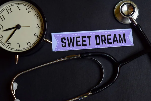 Sweet Dream on the paper with Healthcare Concept Inspiration. alarm clock, Black stethoscope.