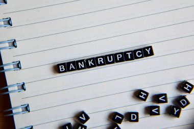 Ahşap blok ve büyüteç üzerinde iflas. Motivasyon kavramı