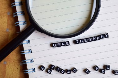 Gene Theraphy ahşap blok ve büyüteç üzerinde. Motivasyon kavramı