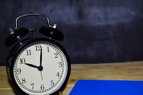 Reloj despertador en fondo negro. concepto de educación —  Fotos de Stock