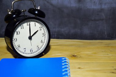 Siyah arka planda çalar saat yüzü. eğitim kavramı