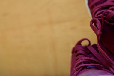 Ahşap arka planda izole kırmızı bir spor ayakkabıları kapatın. Metin tasarımınızı koyun