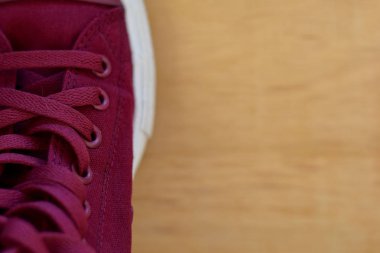 Ahşap arka planda izole kırmızı bir spor ayakkabıları kapatın. Metin tasarımınızı koyun