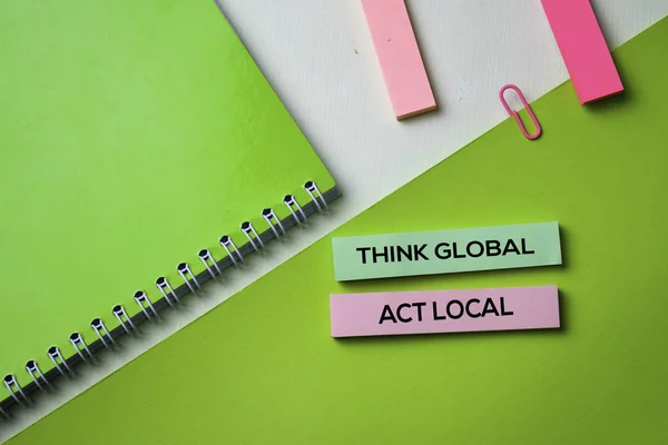 Think Global Act Local text on top view office desk table of Business workplace and business objects.