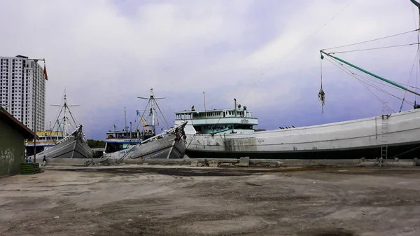 Jakarta, Indonézia, június 18 2019: konténerszállító hajók az export és import üzleti és logisztikai. Rakományok szállítása a kikötőbe daruval. A kikötőben Sunda Kelapa — Stock Fotó