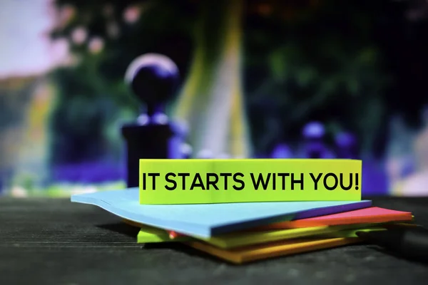 It Starts With You! on the sticky notes with bokeh background