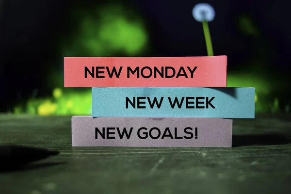 New Monday, New Week, New Goals! on the sticky notes with bokeh background