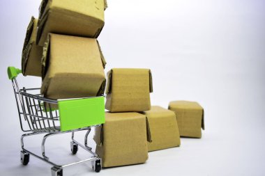 Birçok küçük kutu ve alışveriş sepeti. Online alışveriş ile ilgili kavramlar. Beyaz arka planda yalıtılmış