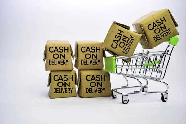 Cash On Delivery Text in small boxes and shopping cart. Concepts about online shopping. Isolated on white background