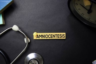 Yapışkan Notlar amniyosentez metin. Üst görünüm siyah arka planda yalıtılmış. Sağlık / Tıp kavramı