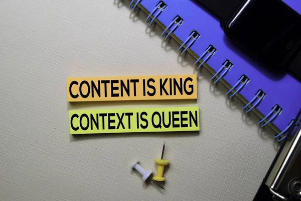 Content is King. Context Is Queen text on sticky notes isolated on office desk