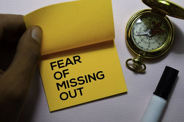 Fear Of Missing Out (FOMO) text on sticky notes isolated on office desk