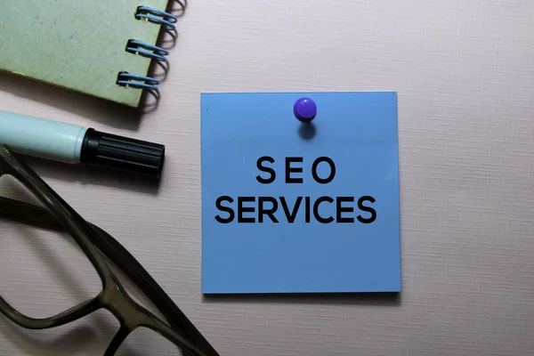 Texto de SEO Services sobre notas adhesivas aisladas en escritorio de oficina — Foto de Stock