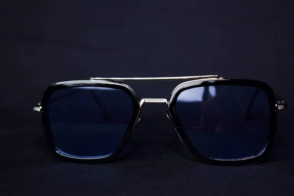 Primer plano de las gafas de sol retro aisladas sobre fondo negro bokeh —  Fotos de Stock
