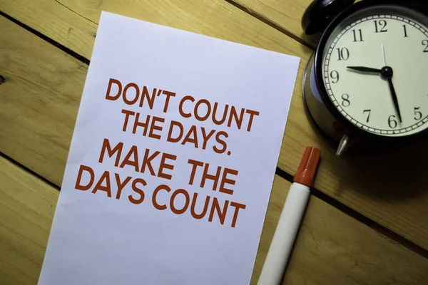 Don\'t Count The Days. Make The Days Count text on the paper isolated on table background