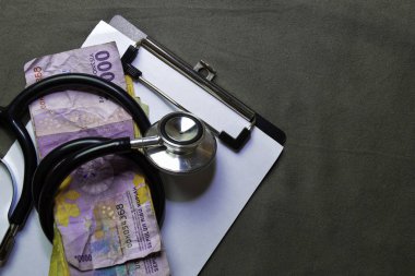 Ofis masasında Endonezya Rupiah ile siyah stetoskop. Finansal kavram
