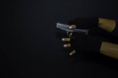 asyalı adam bir silah tutar. Siyah arka planda izole edilmiş hedefini vurarak öldürüldü.