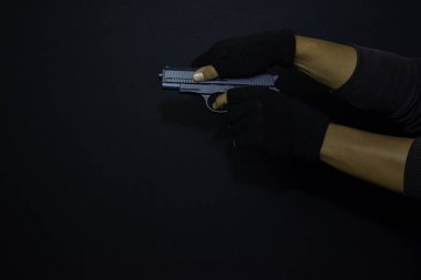 asyalı adam bir silah tutar. Siyah arka planda izole edilmiş hedefini vurarak öldürüldü.