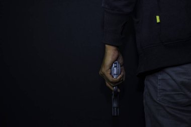 asyalı adam bir silah tutar. Siyah arka plan üzerinde izole arka dan elinde Silah.