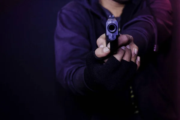 Азіатський чоловік тримає пістолет. Вбитий стрілянина його мішень ізольовано на чорному тлі . — стокове фото