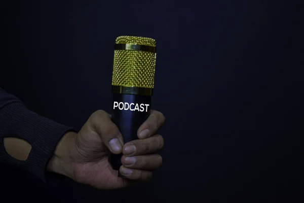 Microfone Profesional em mãos fundo preto isolado. Conceito de Podcast — Fotografia de Stock