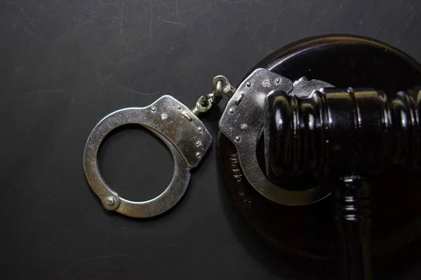 Handcuffs and black gavel isolated on black background. Justice and law concept — Stock Photo, Image