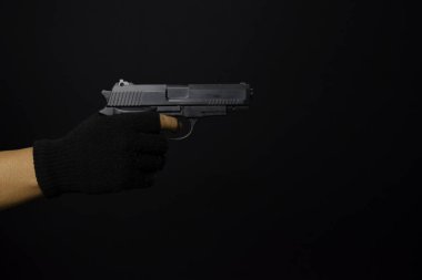 asyalı adam bir silah tutar. Elinde silah. Siyah arka planda izole edilmiş hedefini vurarak öldürüldü.