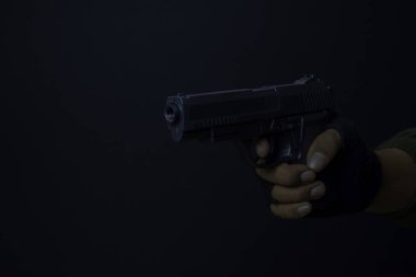 asyalı adam bir silah tutar. Elinde silah. Siyah arka planda izole edilmiş hedefini vurarak öldürüldü.