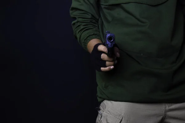 아시아 남자 는 총을 보유합니다. 그의 손에 총. 검은 배경에 고립 된 자신의 목표를 촬영 살해. — 스톡 사진