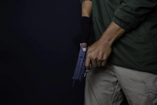 아시아 남자 는 총을 보유합니다. 그의 손에 총. 검은 배경에 고립 된 자신의 목표를 촬영 살해. — 스톡 사진