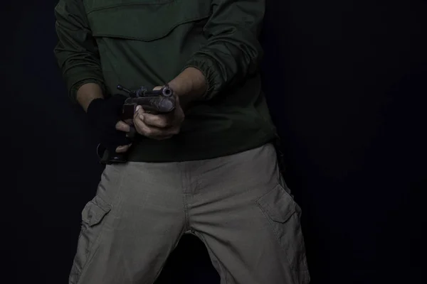Asijský muž má pistoli. Pistoli v jeho ruce. Zabit při natáčení svého cíle izolovaně na černém pozadí. — Stock fotografie