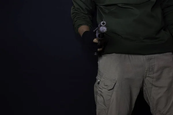 Asiático homem segura uma arma. Uma arma na mão dele. Morto atirando seu alvo isolado em fundo preto . — Fotografia de Stock