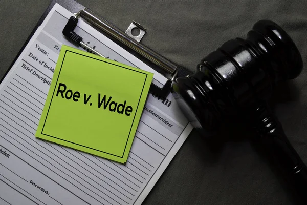 Roe v. Wade sur des notes collantes et un marteau isolé sur un bureau. Concept de droit — Photo