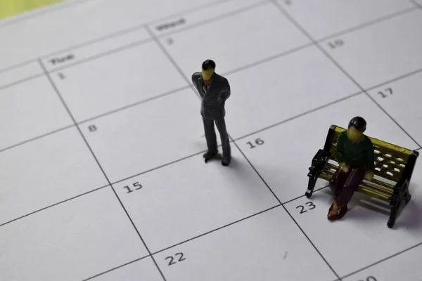 Personas en miniatura de pie y sentados que piensan salario en el 15 en el calendario. Horario, concepto de recordatorio — Foto de Stock