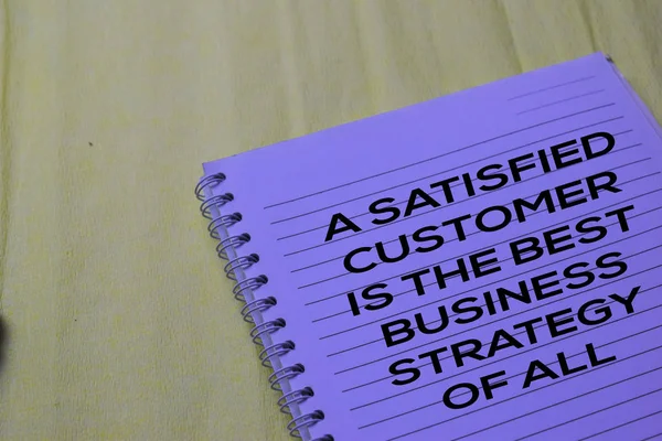 Un cliente satisfecho es la mejor estrategia de negocio de todo el texto en un libro . — Foto de Stock