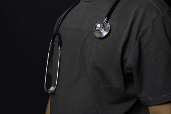 Nahaufnahme Arzt mit Stethoskop isoliert auf schwarzem Hintergrund — Stockfoto