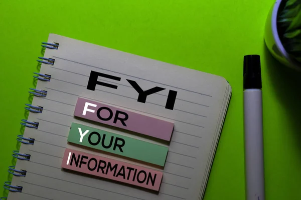 FYI. For Your Information acronym on sticky notes. Office desk background