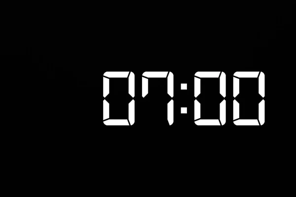 Ώρα έναρξης 07: 00 σε λευκό LED ψηφιακό ρολόι απομονωμένο μαύρο φόντο — Φωτογραφία Αρχείου