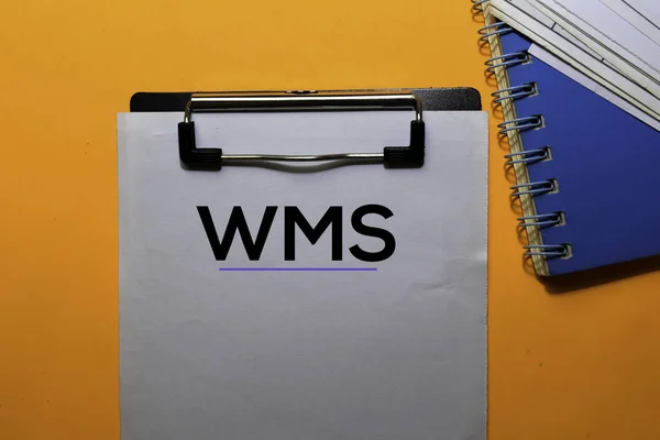 Τα wms γράφουν στα χαρτιά. Απομονωμένα σε πορτοκαλί φόντο πίνακα — Φωτογραφία Αρχείου
