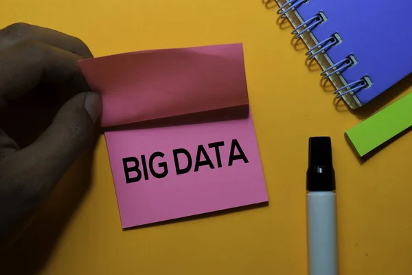 Τα μεγάλα δεδομένα γράφουν σε κολλώδεις σημειώσεις. Απομονωμένα σε πορτοκαλί φόντο πίνακα — Φωτογραφία Αρχείου