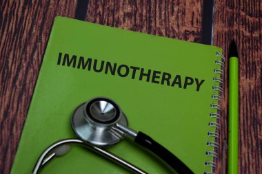 Book about Immunotherapy isolated on wooden table.