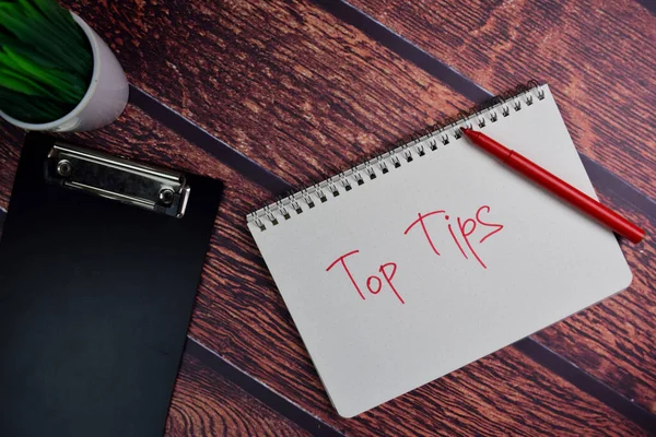 Top Tips write on a book isolated wooden table.