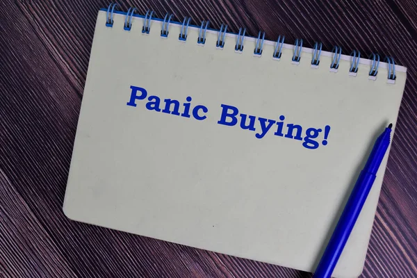 Panic Buying write on a book isolated wooden table.