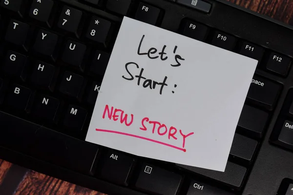Let\'s Start - New Story text on sticky notes with office desk.