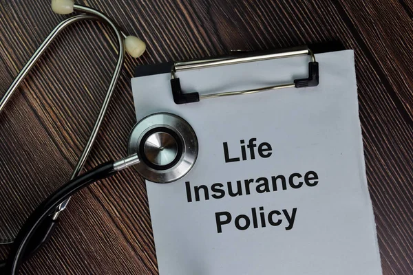 Life Insurance Policy write on a paperwork isolated on wooden table.