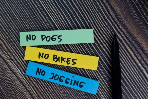 No Dogs, No Bikes, No Jogging write on sticky notes isolated on office desk.