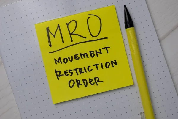MRO - Movement Restriction Order write on sticky notes isolated on office desk.
